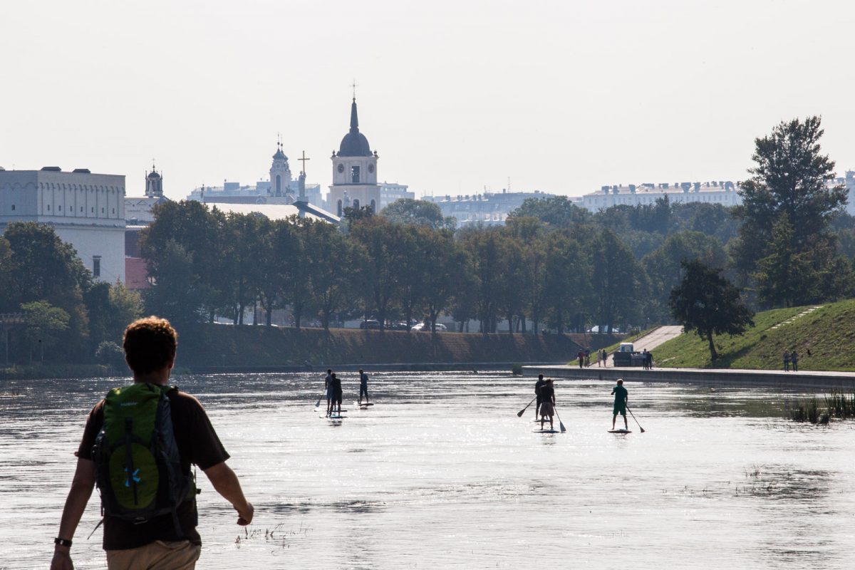 Tourists and locals enjoy summertime by Neris River, in Vilnius Lithuania